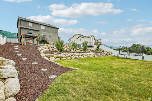 203 North 1900th Street West Mapleton, UT 84664 - Photo 38 of 48 Expansive green lawn with a rock retaining wall and a terraced landscape