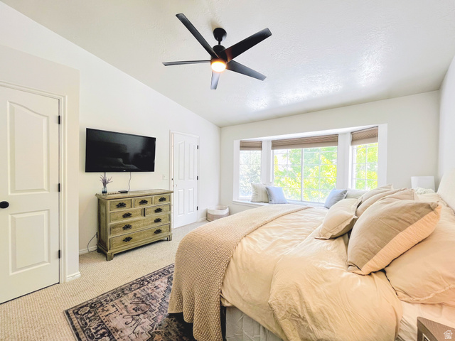 12169 Hidden Valley Road, Unit 44 Sandy, UT 84092 - Photo 20 of 49 Recessed bay window with integrated bench seating, modern ceiling fan with lighting, wall-mounted television, and neutral carpet flooring