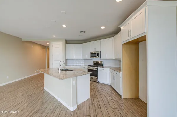 a kitchen with stainless steel appliances granite countertop a sink stove and refrigerator