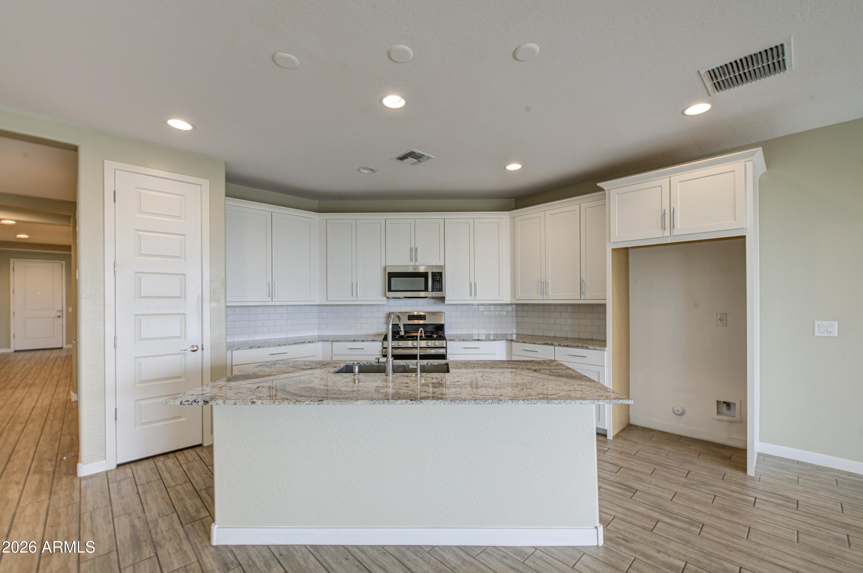 12409 East Soloman Road Gold Canyon, AZ 85118 - Photo 14 of 48 a kitchen with kitchen island a sink a stove a refrigerator and white cabinets