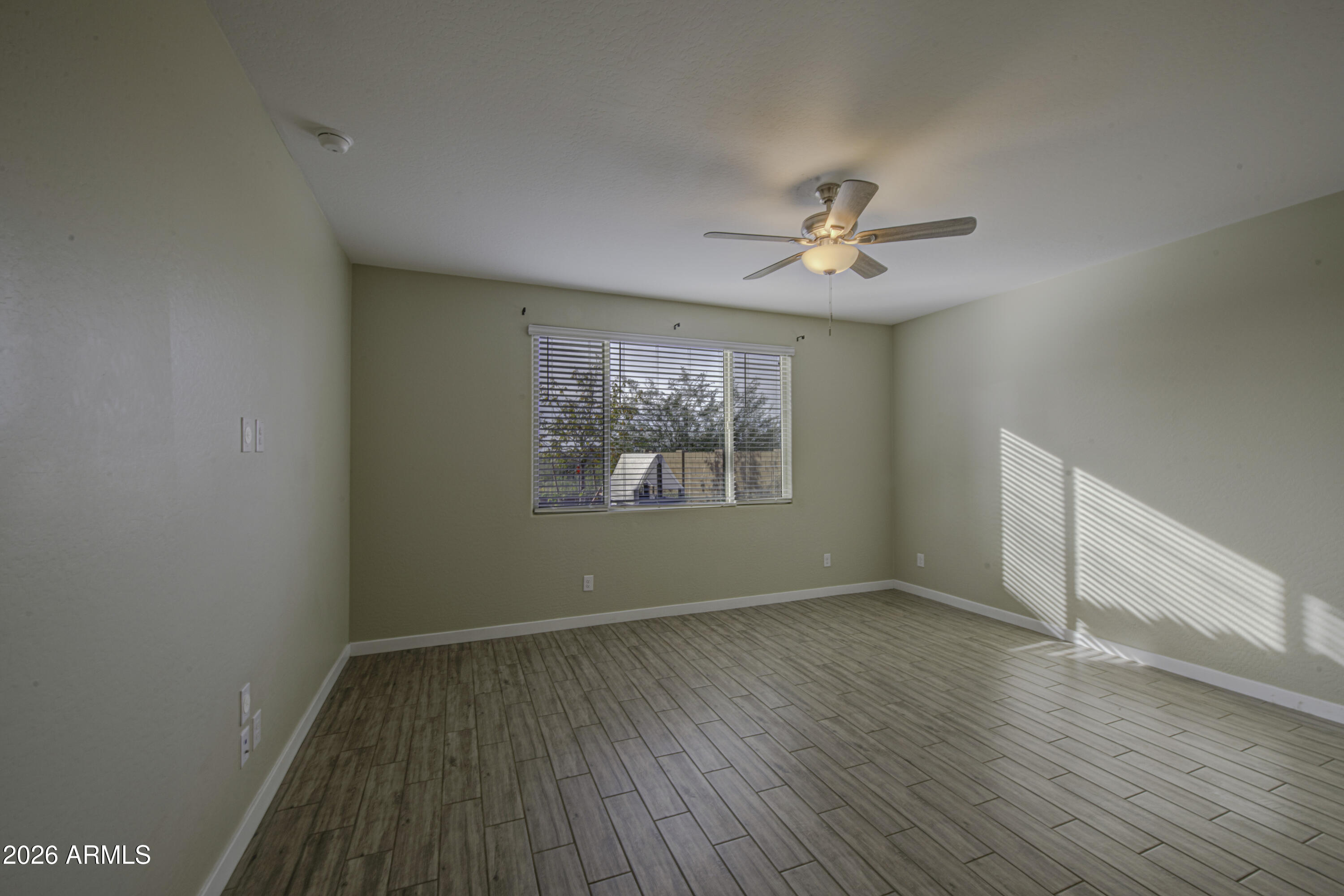 12409 East Soloman Road Gold Canyon, AZ 85118 - Photo 18 of 48 an empty room with wooden floor chandelier fan and windows