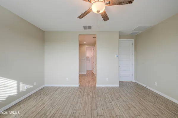 a view of an empty room with wooden floor and window