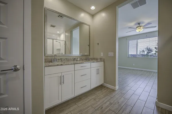 a spacious bathroom with a granite countertop sink a mirror and a