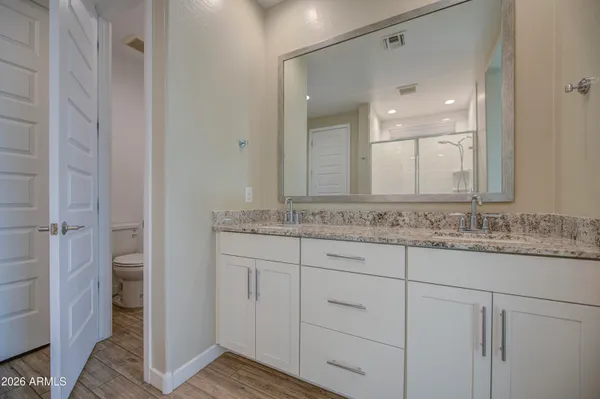a bathroom with a granite countertop sink and a mirror