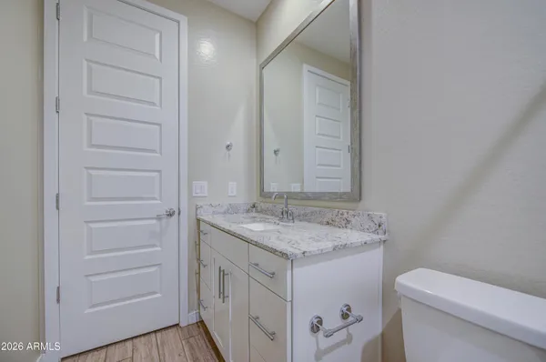 a bathroom with a granite countertop sink and a mirror