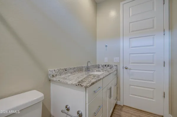 a bathroom with a granite countertop sink and a toilet