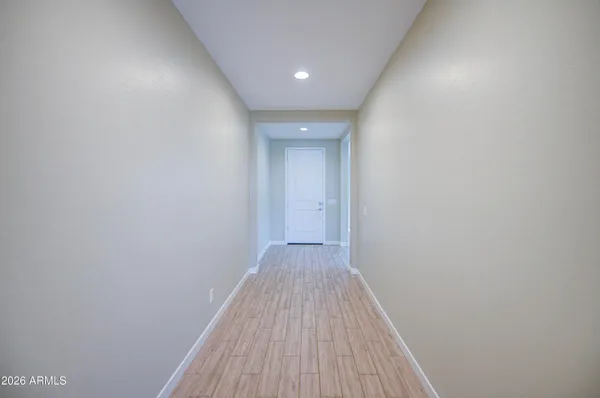 a view of a hallway with wooden floor