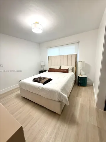 a bedroom with a bed and a night stand