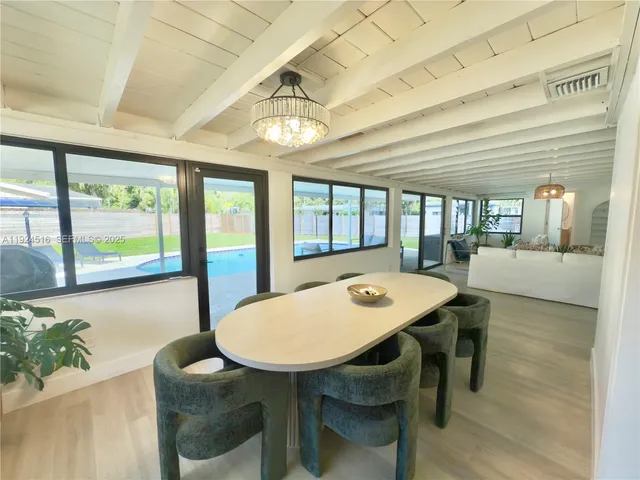 a view of a dining room with furniture large windows and wooden floor
