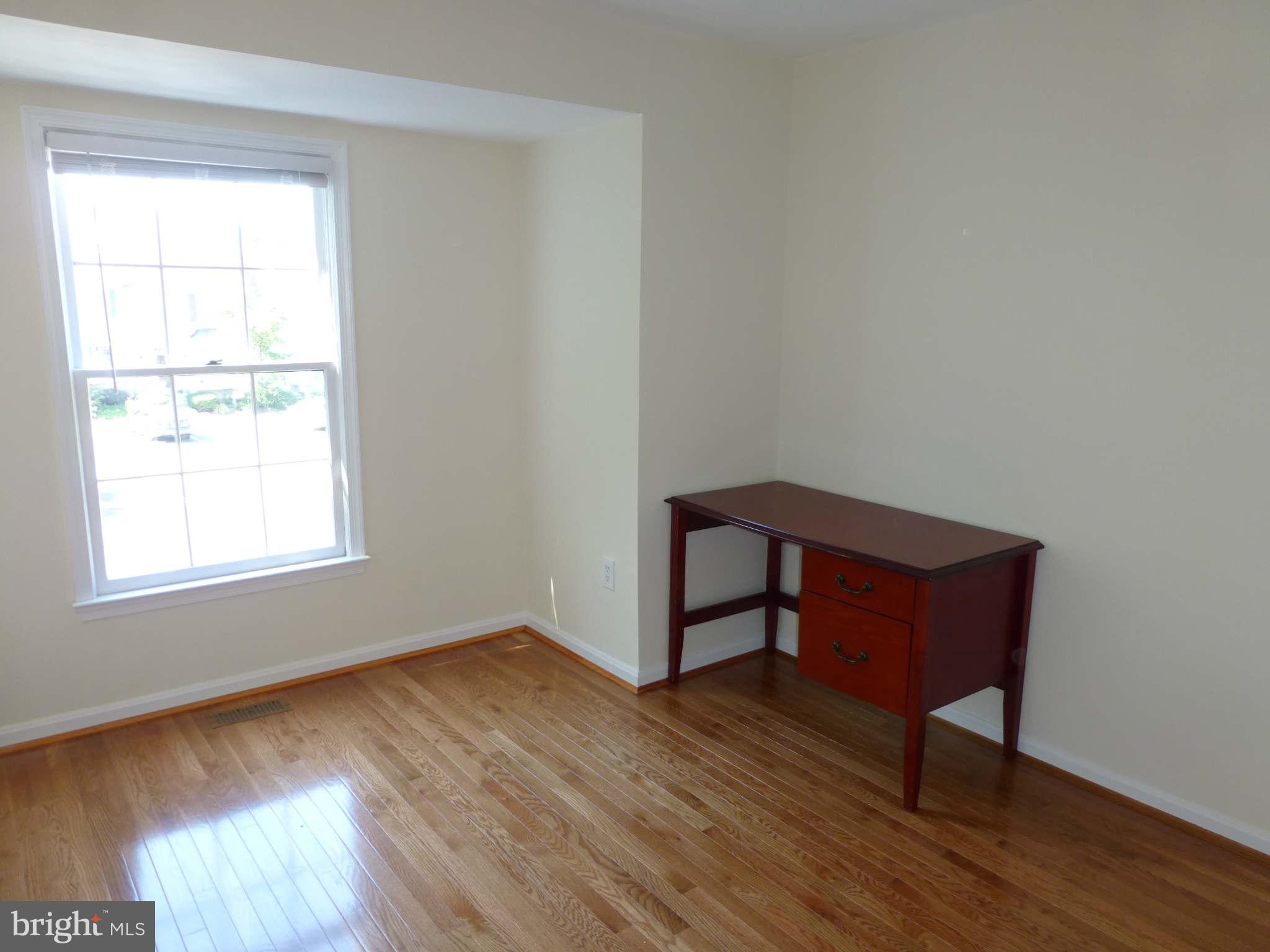 7311 Treetop Hill Lane Springfield, VA 22152 - Photo 18 of 26 an empty room with wooden floor and windows
