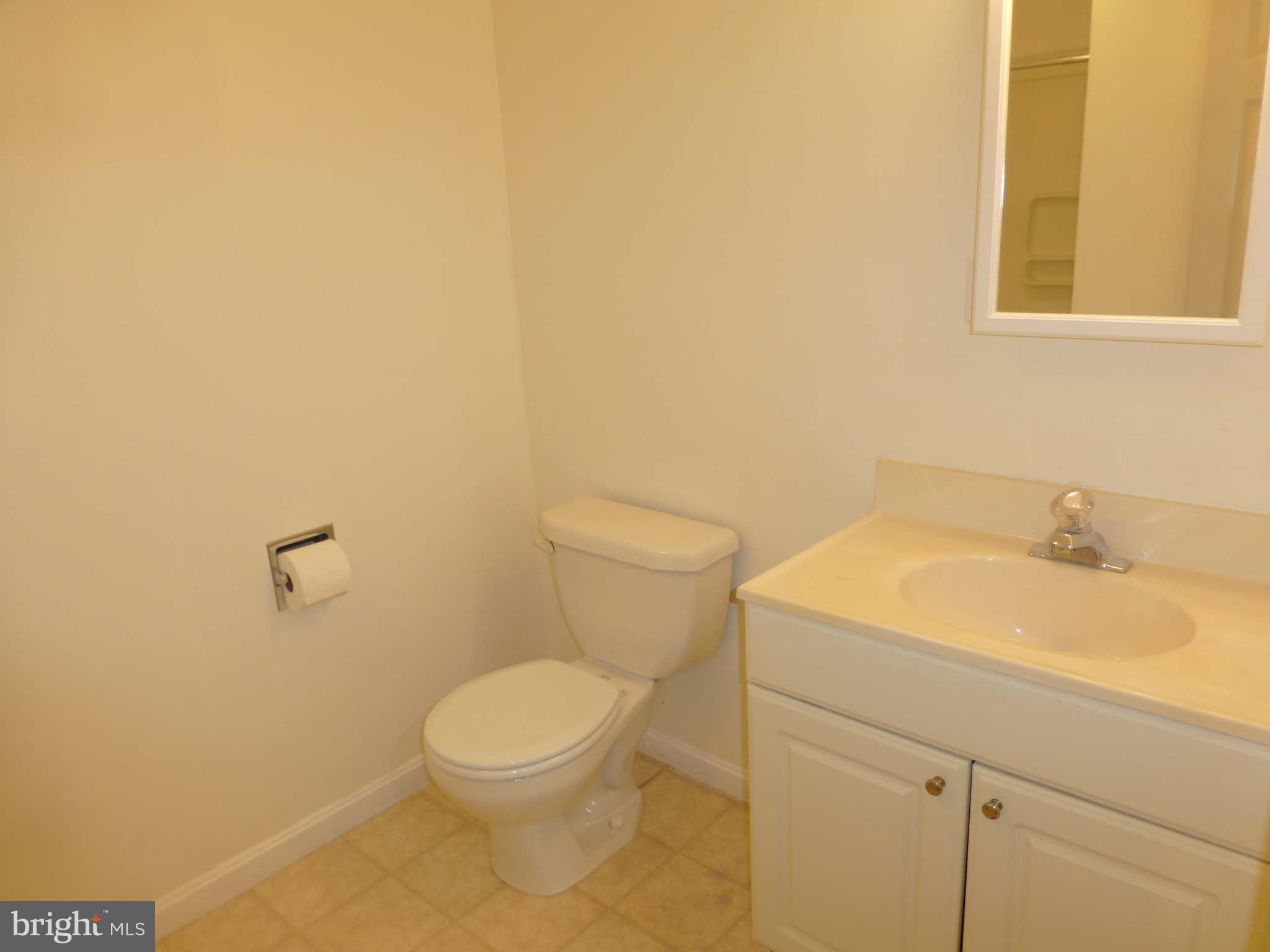7311 Treetop Hill Lane Springfield, VA 22152 - Photo 21 of 26 a bathroom with a toilet a sink and mirror