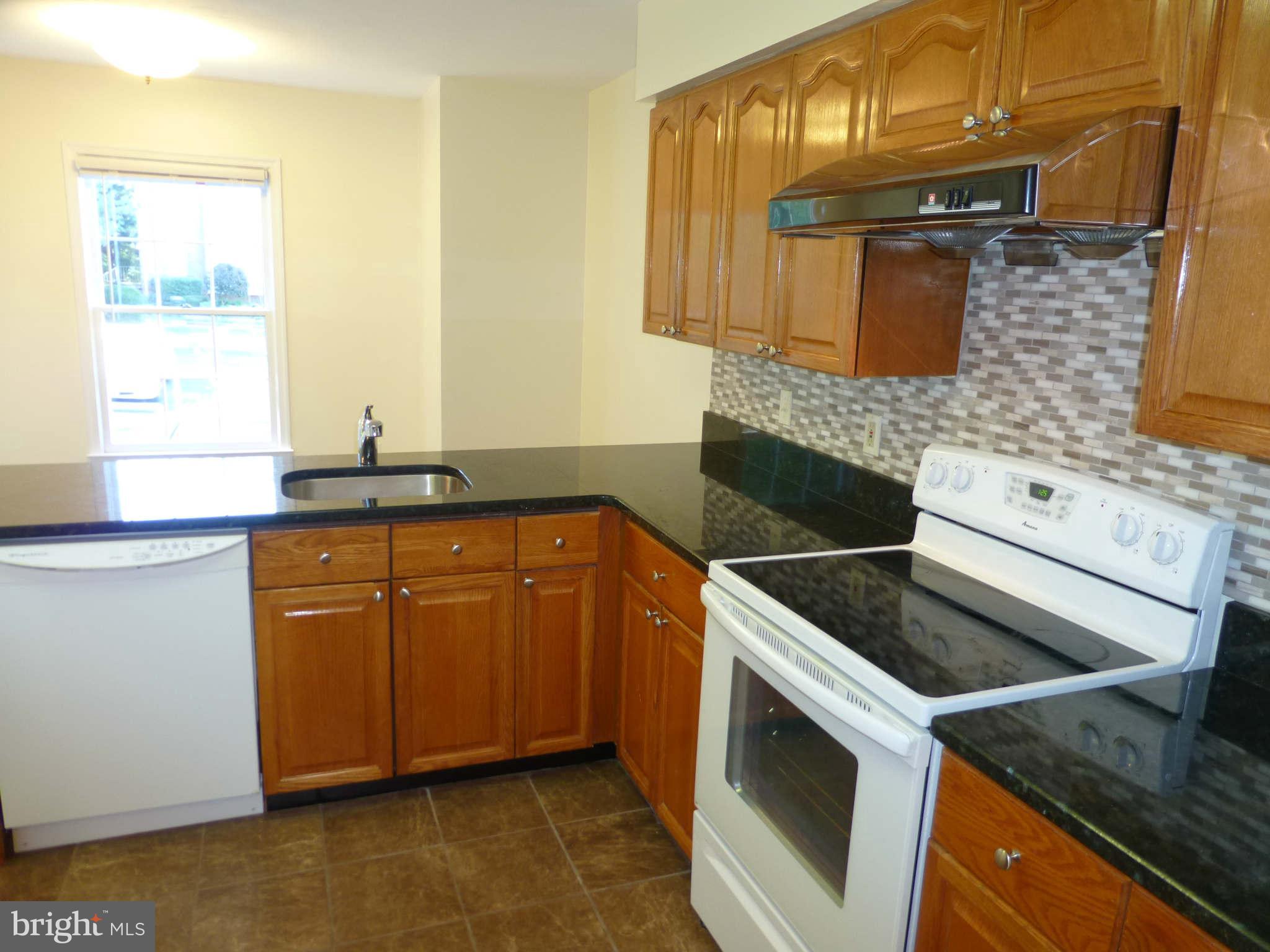 7311 Treetop Hill Lane Springfield, VA 22152 - Photo 6 of 26 a kitchen with granite countertop a sink stove and cabinets