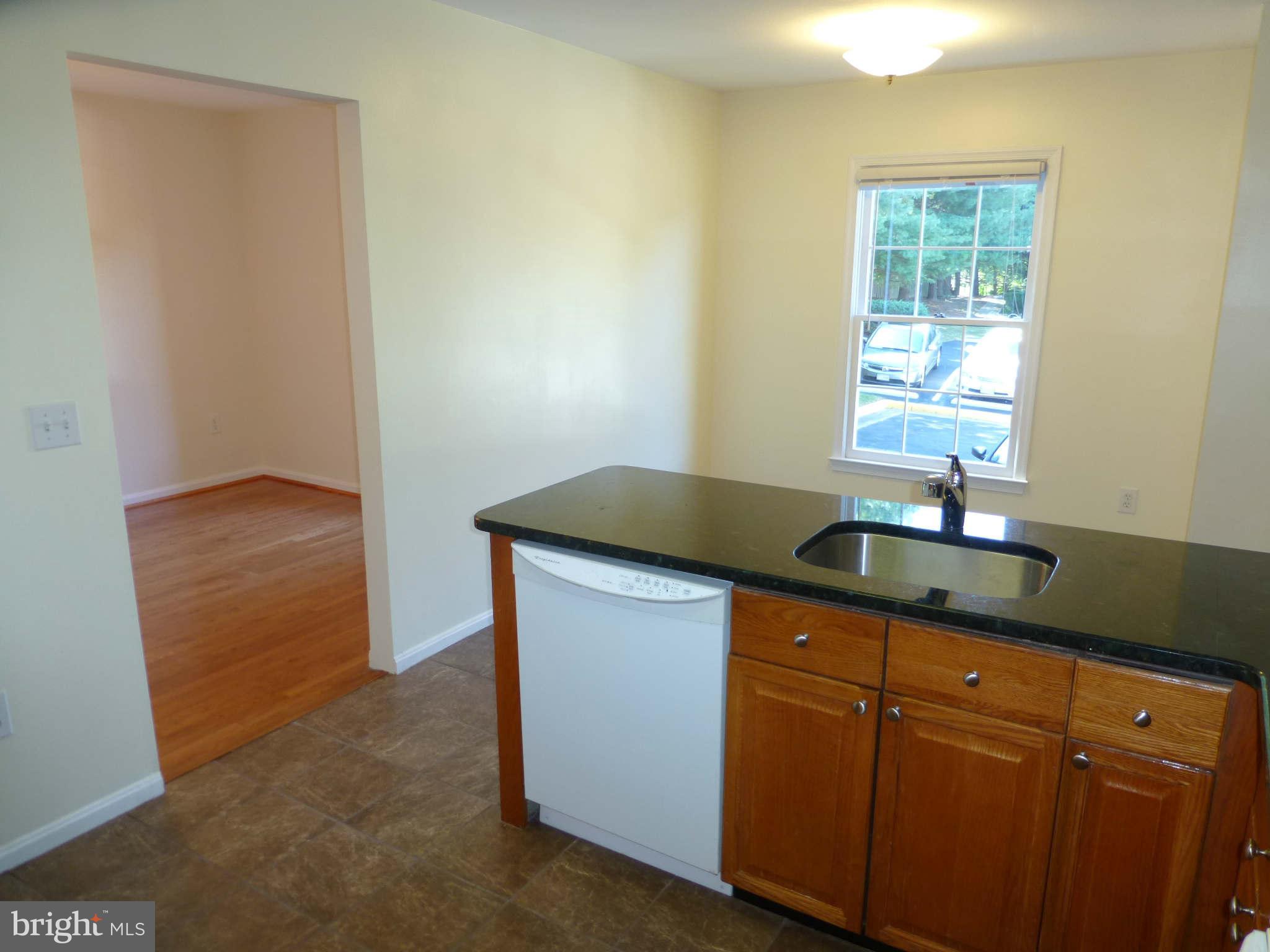 7311 Treetop Hill Lane Springfield, VA 22152 - Photo 9 of 26 a kitchen with granite countertop white cabinets and sink