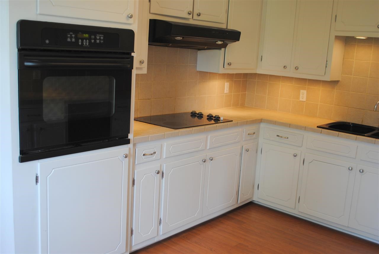 16330 Dunn Road Dunn, NC 28334 - Photo 8 of 21 a kitchen with granite countertop white cabinets and a stove
