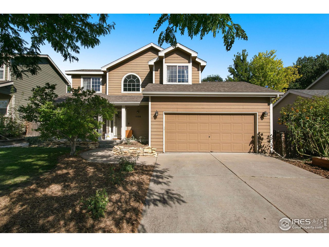 1138 Argento Drive Fort Collins, CO 80521 - Photo 2 of 25 a front view of a house with a yard and garage