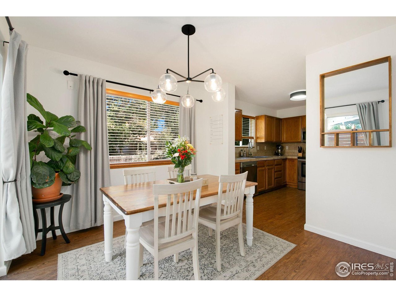 1138 Argento Drive Fort Collins, CO 80521 - Photo 6 of 25 a dining room with furniture a chandelier and wooden floor
