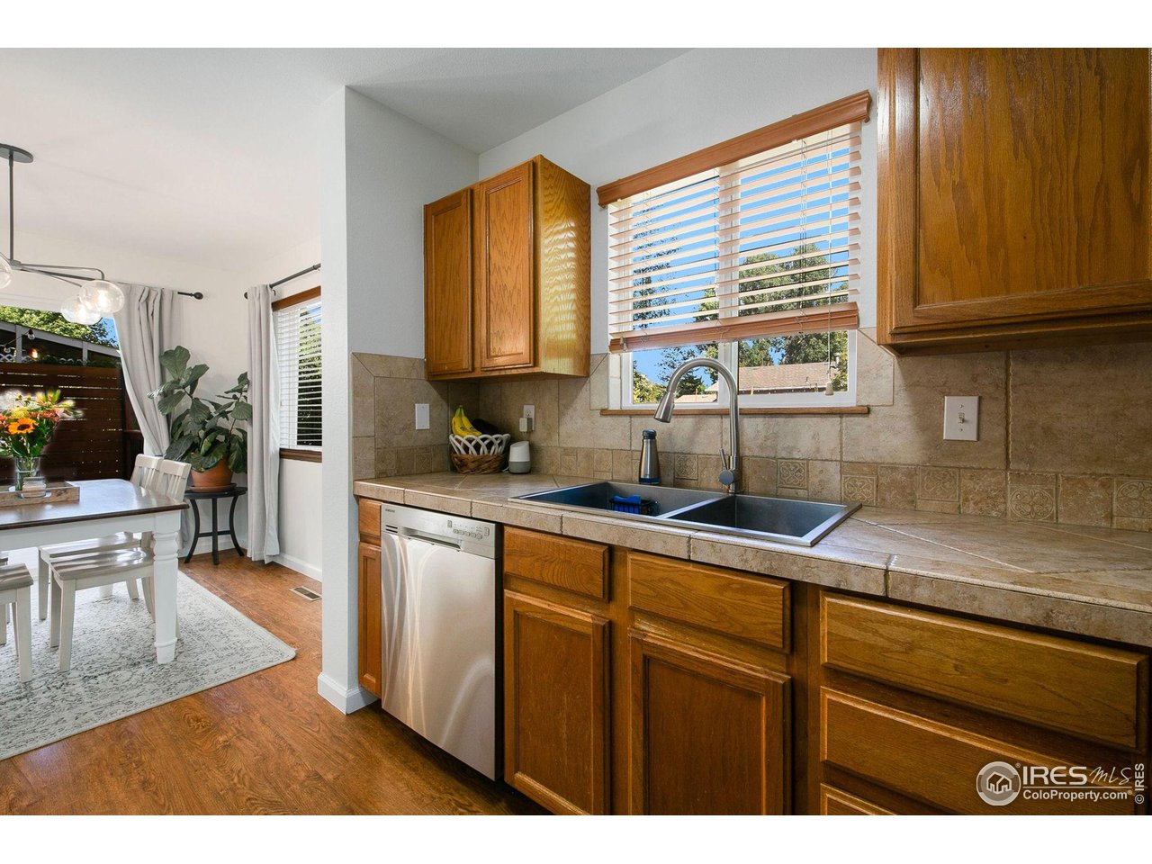 1138 Argento Drive Fort Collins, CO 80521 - Photo 8 of 25 a kitchen with stainless steel appliances granite countertop wooden cabinets a sink a stove a dining table and chairs