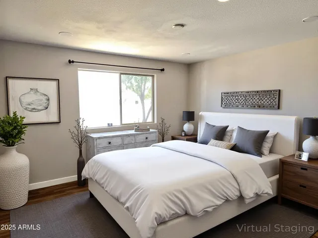a bedroom with a large bed and a potted plant