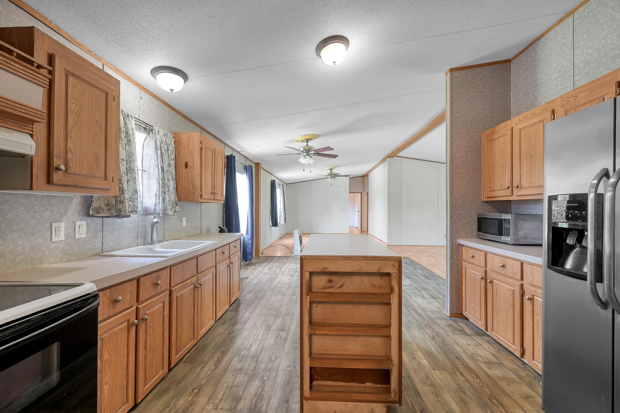 15350 Old Humble Pipeline Road Conroe, TX 77302 - Photo 7 of 38 a large kitchen with stainless steel appliances kitchen island granite countertop a refrigerator a sink dishwasher a stove and white countertops with wooden floor