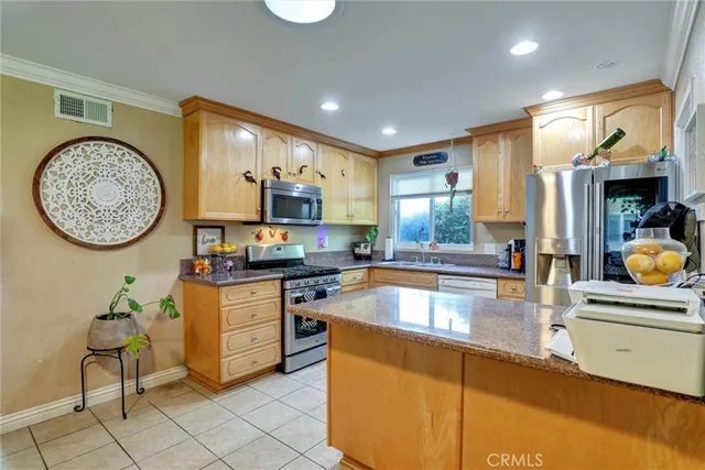 a kitchen with stainless steel appliances granite countertop a stove a sink and a microwave