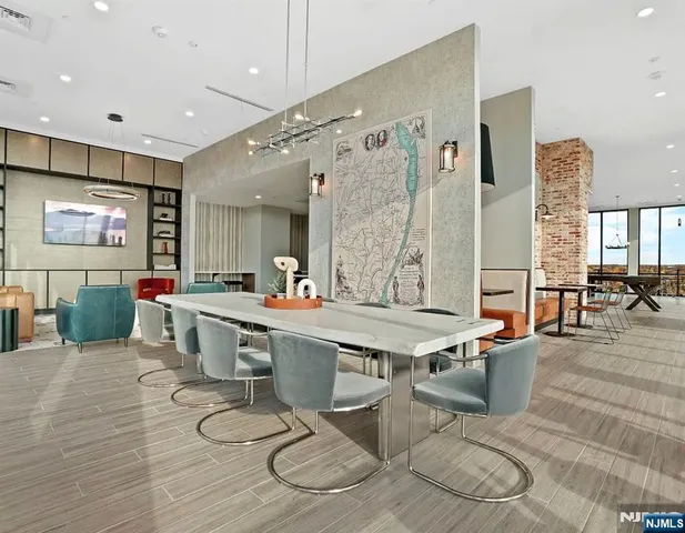 a large dining hall with stainless steel appliances kitchen island granite countertop a table chairs and a living room view