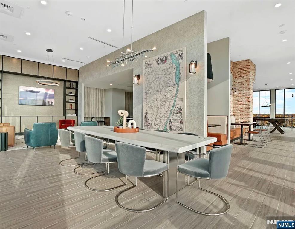 150 Main Street, Unit 405 Hackensack, NJ 07601 - Photo 11 of 12 a large dining hall with stainless steel appliances kitchen island granite countertop a table chairs and a living room view