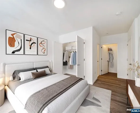 a bedroom with a bed and painting on the wall