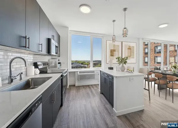 a kitchen with counter top space a sink appliances and cabinets