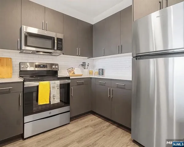 a kitchen with stainless steel appliances a stove microwave and refrigerator