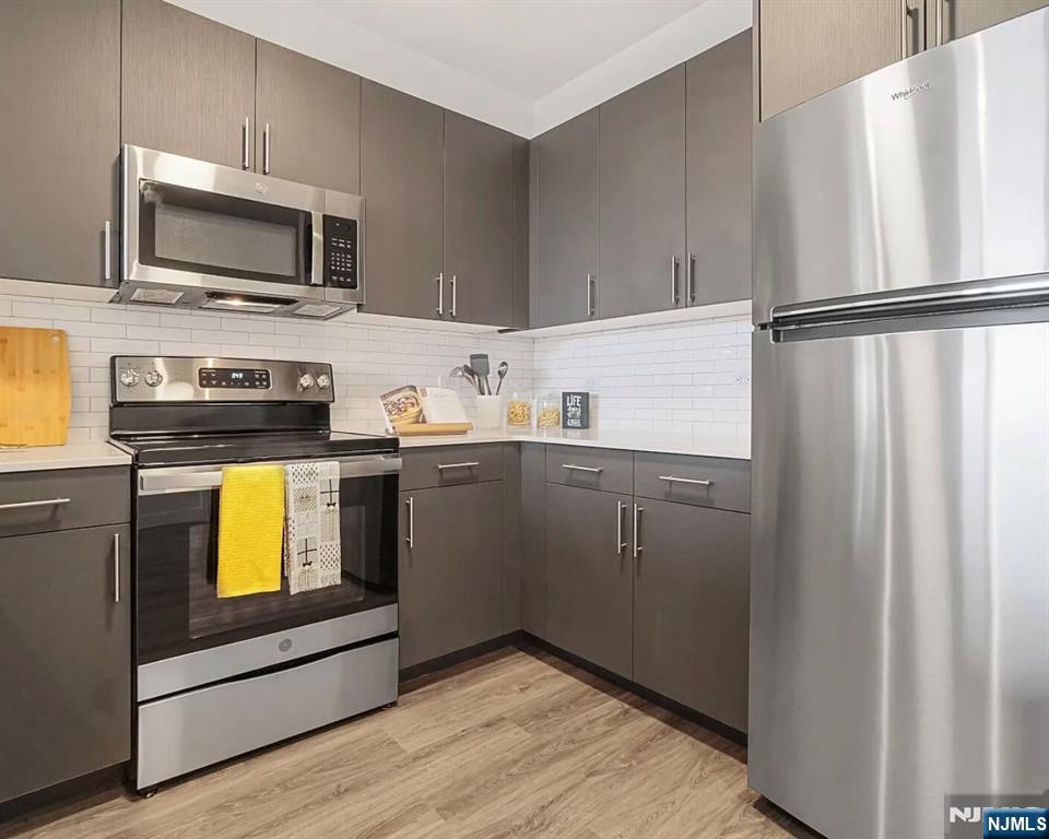 150 Main Street, Unit 405 Hackensack, NJ 07601 - Photo 10 of 12 a kitchen with stainless steel appliances a stove microwave and refrigerator