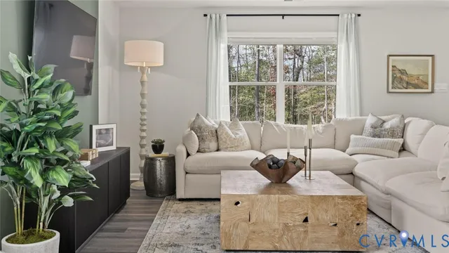 a living room with furniture a potted plant and a large window