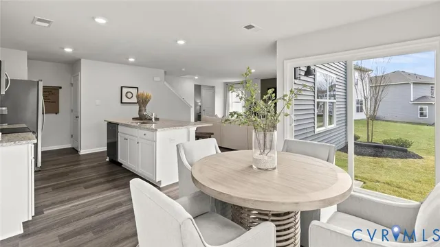 a kitchen with stainless steel appliances a dining table and chairs