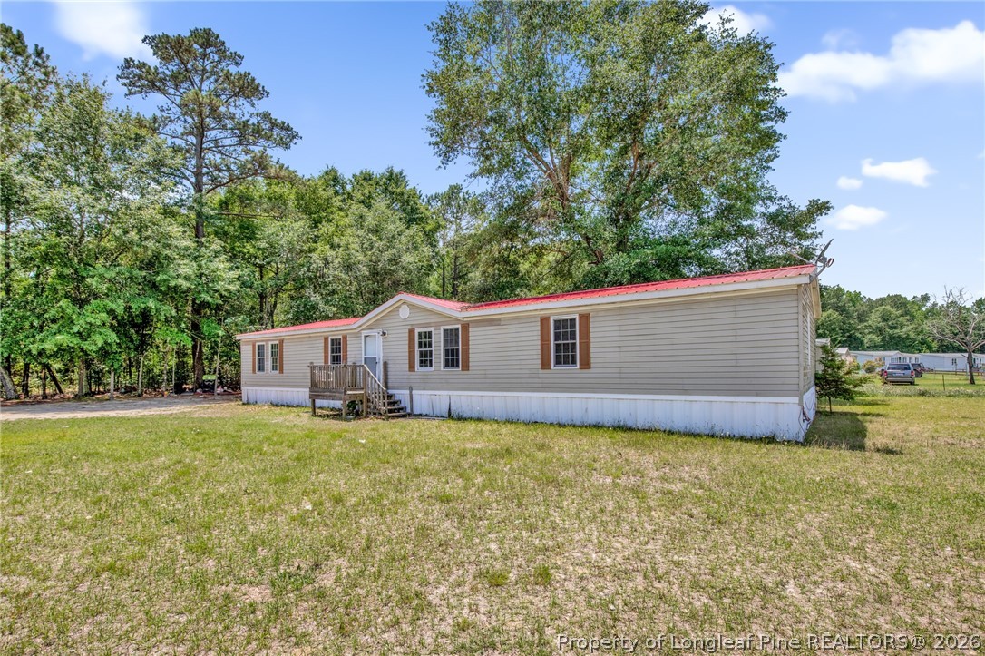 4705 Hickory Ridge Road Parkton, NC 28371 - Photo 4 of 37 a house that is sitting in the grass with large trees