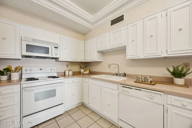 a kitchen with white cabinets and white appliances