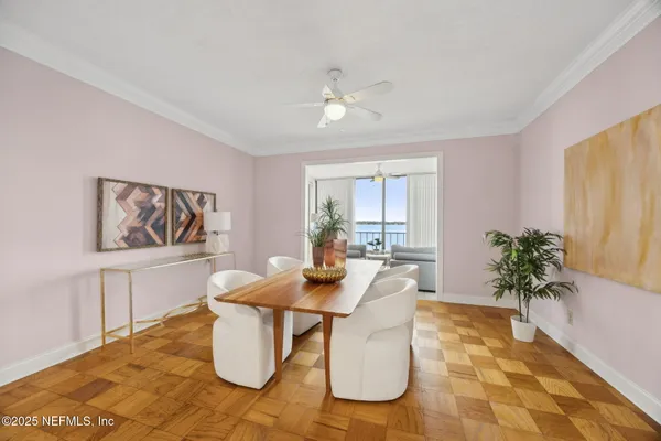 a dining room with furniture and a potted plant