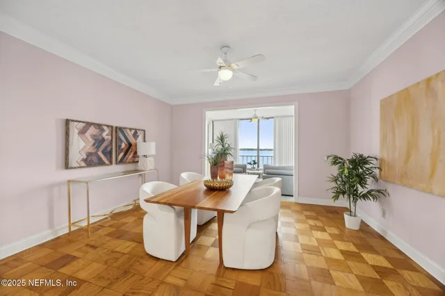 a dining room with furniture and a potted plant