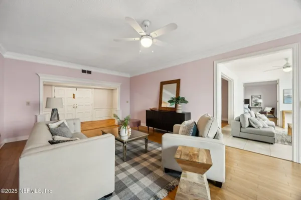 a living room with furniture and a dining table with potted plant