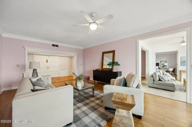 a living room with furniture and a dining table with potted plant