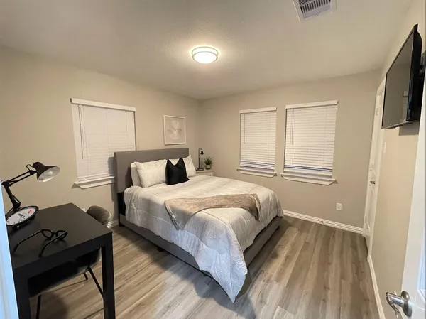 a bedroom with a bed and wooden floor
