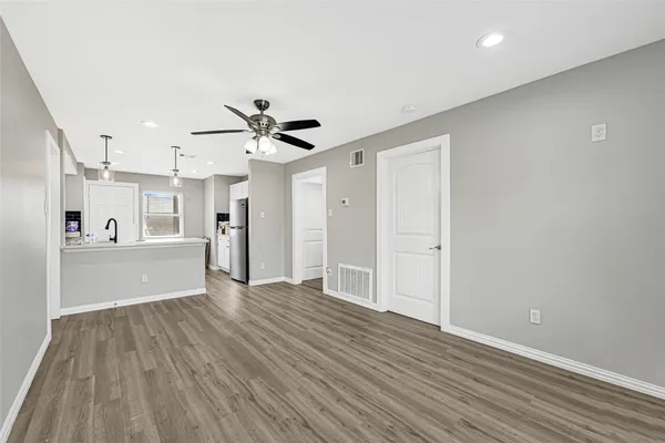 a view of a kitchen with wooden floor and a ceiling fan