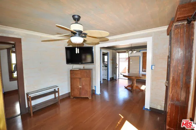 a view of a livingroom with wooden floor and a ceiling fan