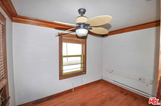 a view of empty room with window and chandelier fan