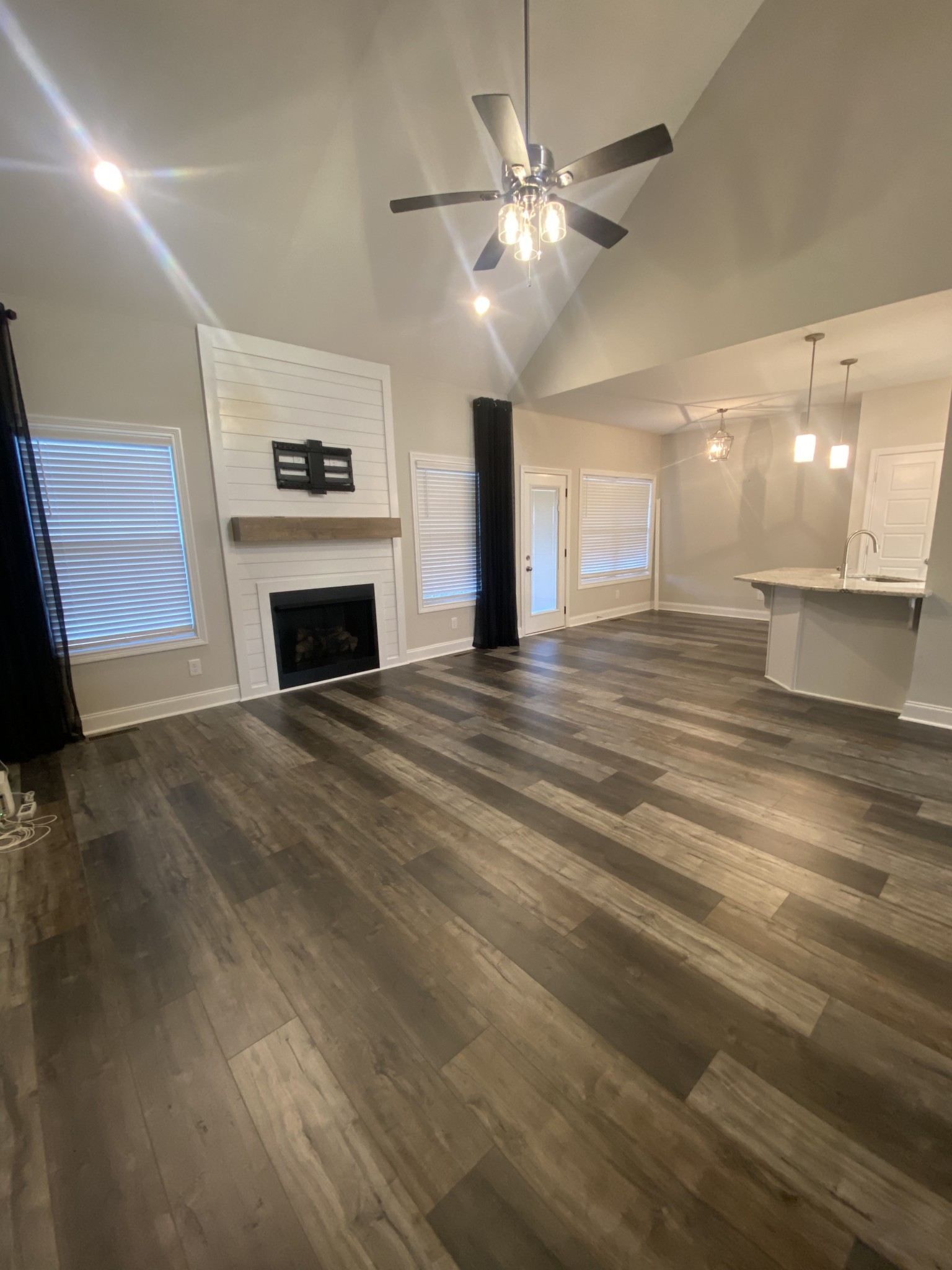 557 Dexter Drive Clarksville, TN 37043 - Photo 6 of 30 a view of a livingroom with a fireplace a chandelier a wooden table and chairs