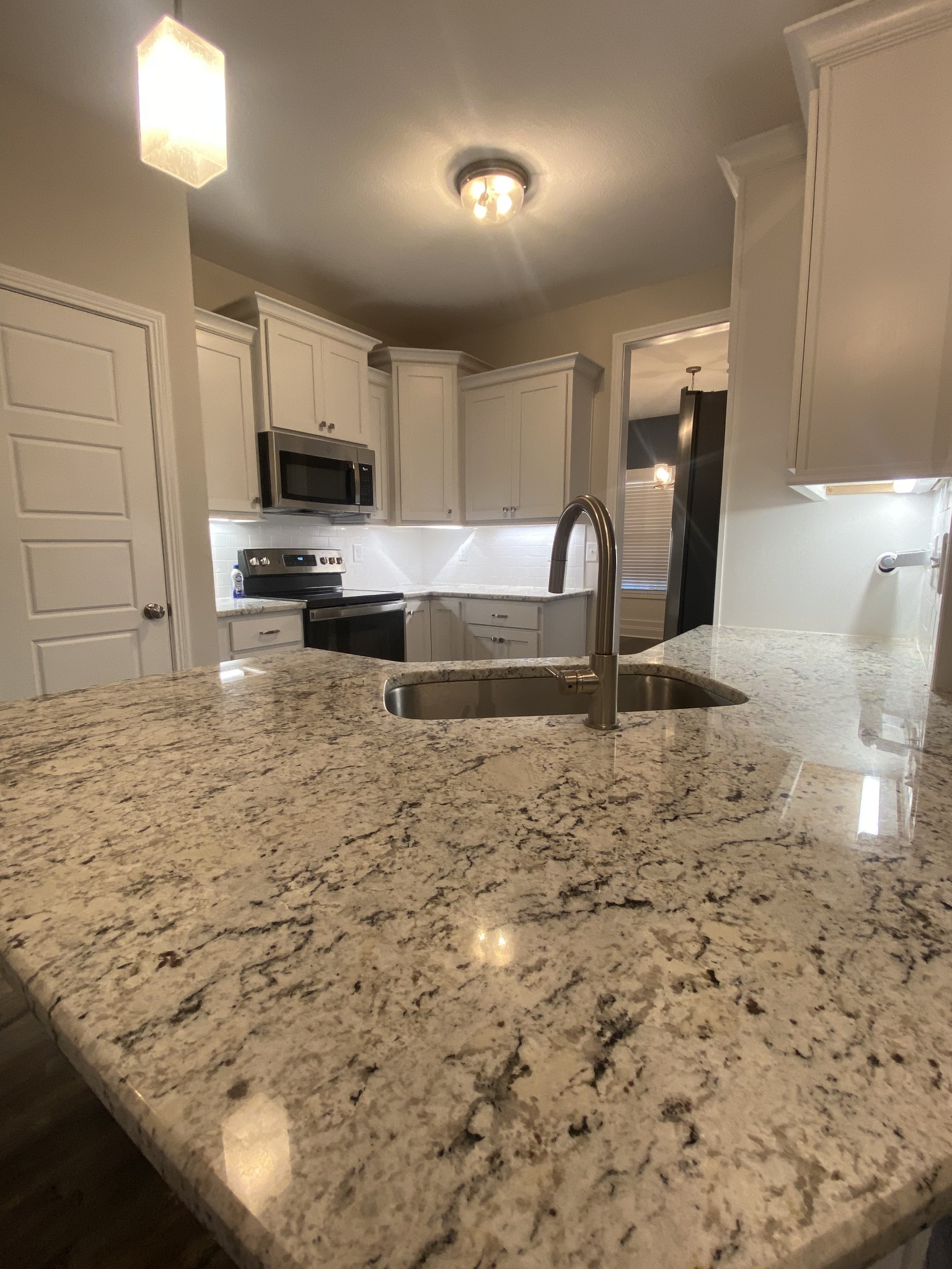 557 Dexter Drive Clarksville, TN 37043 - Photo 8 of 30 a kitchen with kitchen island granite countertop a stove a sink and a microwave