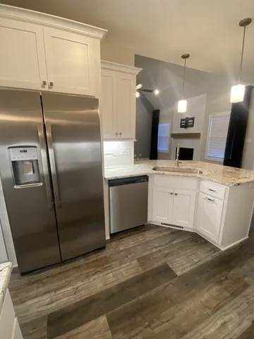 a kitchen with granite countertop white cabinets and black appliances