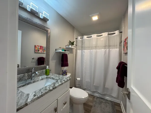 a bathroom with a granite countertop sink toilet and shower
