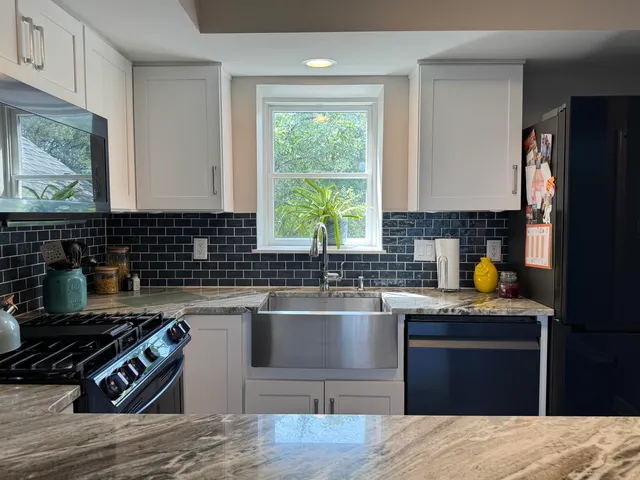 a kitchen with granite countertop a stove a sink and a wooden cabinets