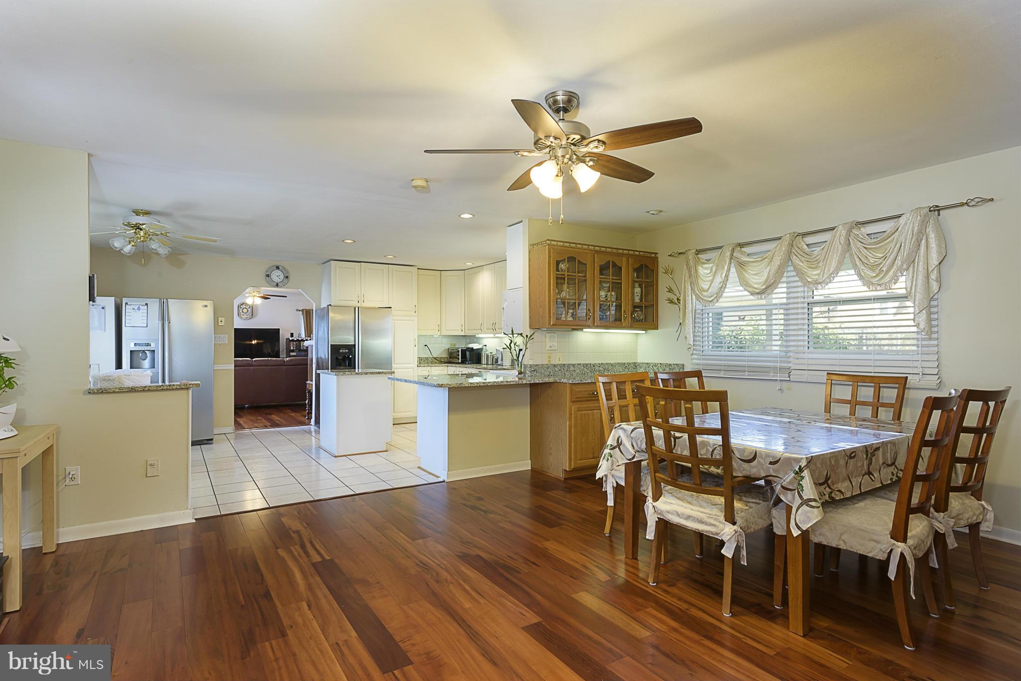 12013 Marvel Lane Bowie, MD 20715 - Photo 10 of 22 a kitchen with stainless steel appliances a dining table chairs and wooden floor
