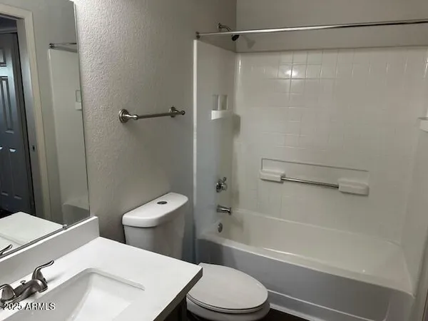 a white toilet sitting next to a bath tub