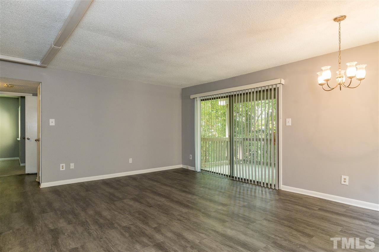 611 Pine Ridge Place, Unit 611 Raleigh, NC 27609 - Photo 9 of 26 en empty room with wooden floor and outdoor view